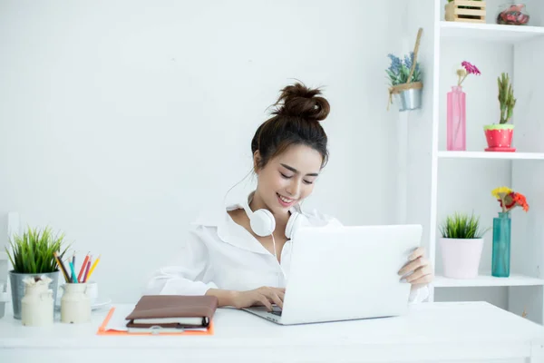 Hermosa joven mujer trabajando en su portátil en su habitación . — Foto de Stock