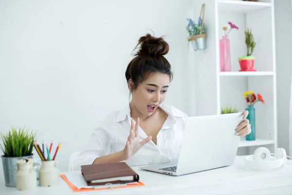 Красива молода жінка працює на ноутбуці у своїй кімнаті . — стокове фото