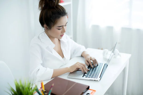 Mulher bonita trabalhando em seu laptop em seu quarto . — Fotografia de Stock