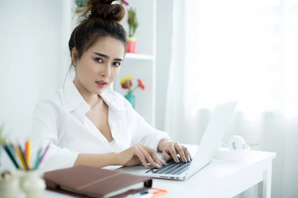 Mulher bonita trabalhando em seu laptop em seu quarto . — Fotografia de Stock