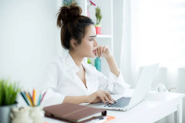 Hermosa joven mujer trabajando en su portátil en su habitación . — Foto de Stock