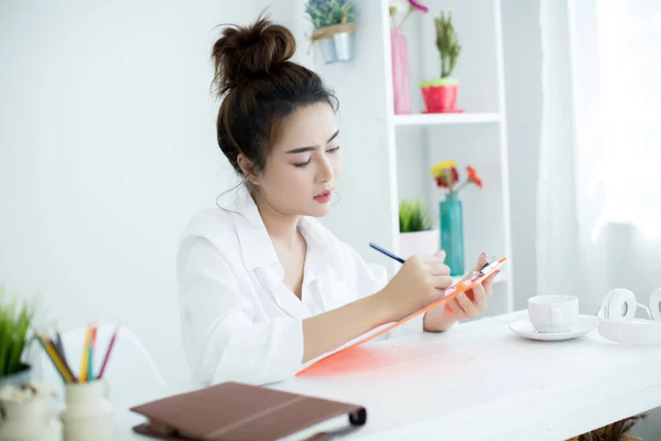 Beautiful young woman working on her laptop in her room. — ストック写真