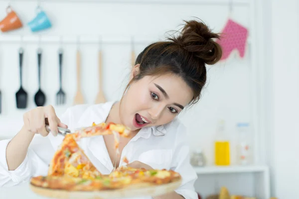 Mujer disfrutando de la pizza en su habitación — Foto de Stock
