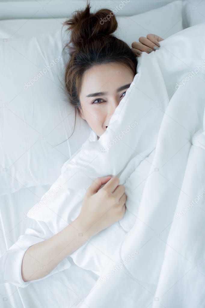 Beautiful young woman lying down in the bed and sleeping.