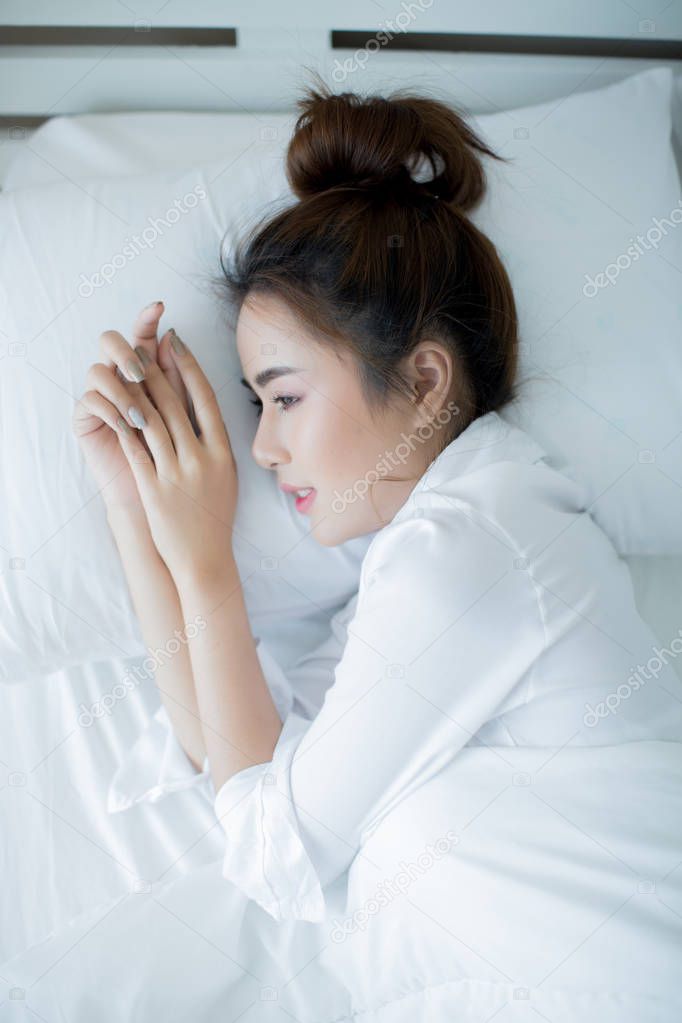 Beautiful young woman lying down in the bed and sleeping.
