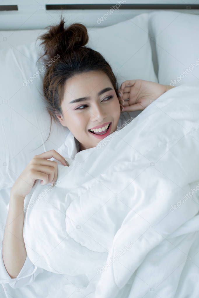 Beautiful young woman lying down in the bed and sleeping.