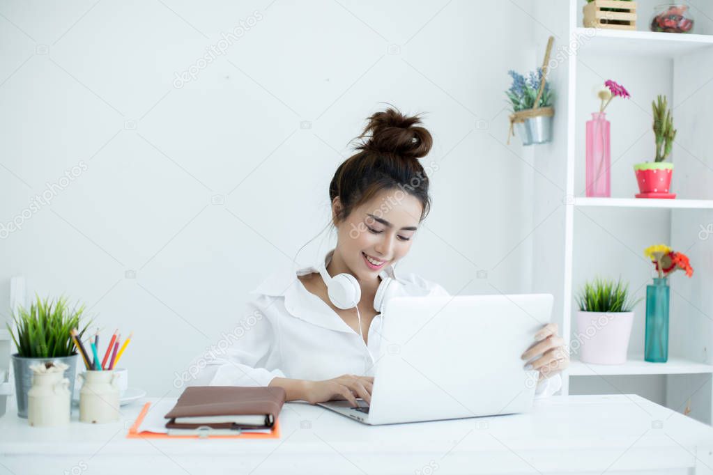 Beautiful young woman working on her laptop in her room.