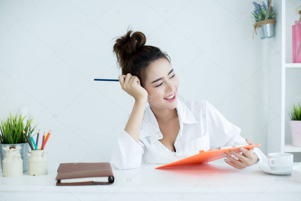 Beautiful young woman working on her laptop in her room.