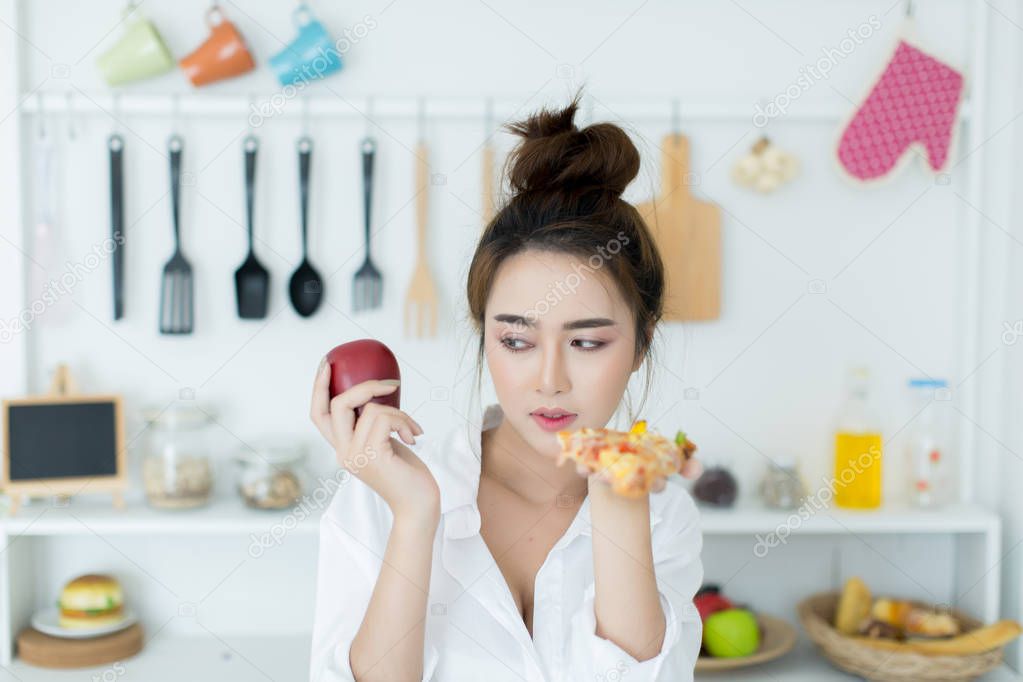 woman choosing between apple and pizza