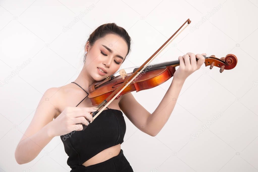 Beautiful young woman playing violin over white background