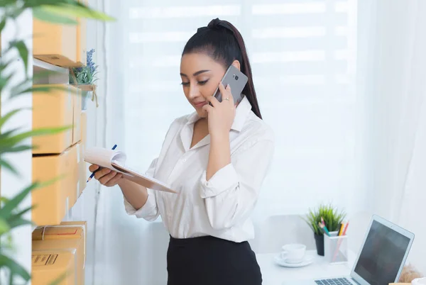 Business ägare arbetar hemma Office förpackningar på bakgrunden Stockbild