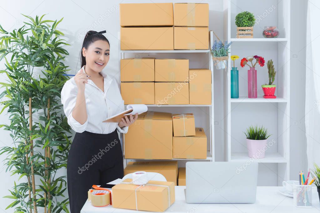 business owner working at home office packaging on background