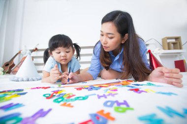 Anne ve kızı alfabe okuyor