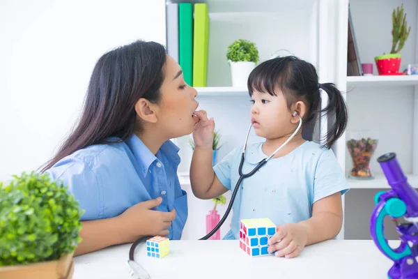 Mother and daughter playing doctor with stethoscope