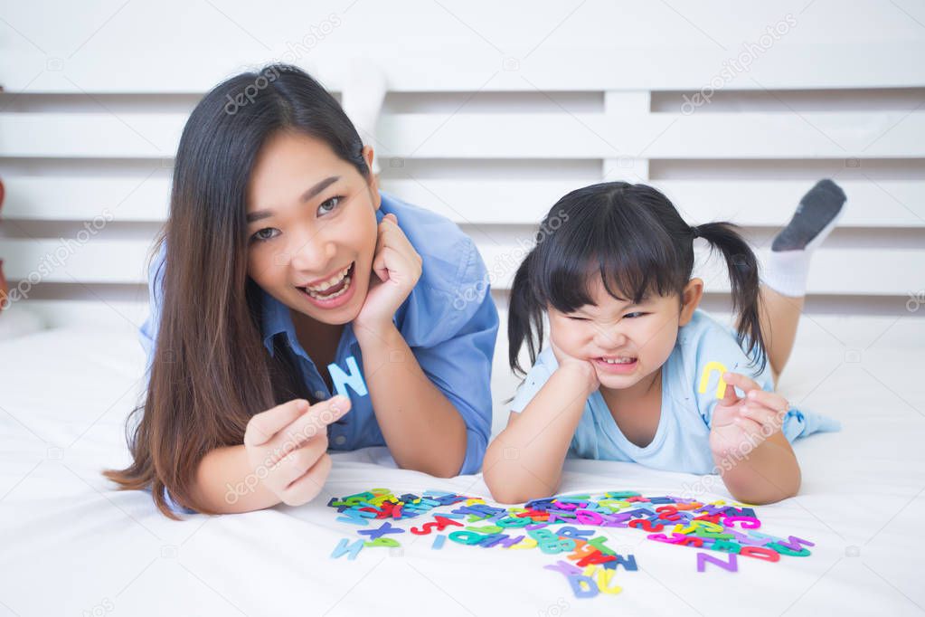 Mother and daughter studying the alphabet