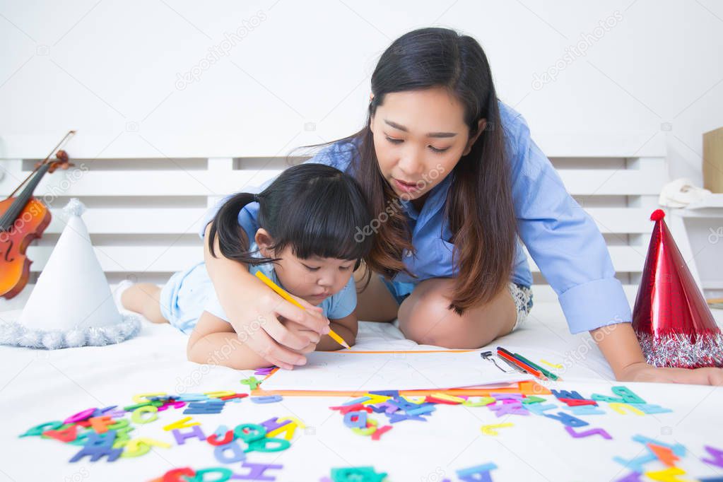 Mother and daughter studying the alphabet