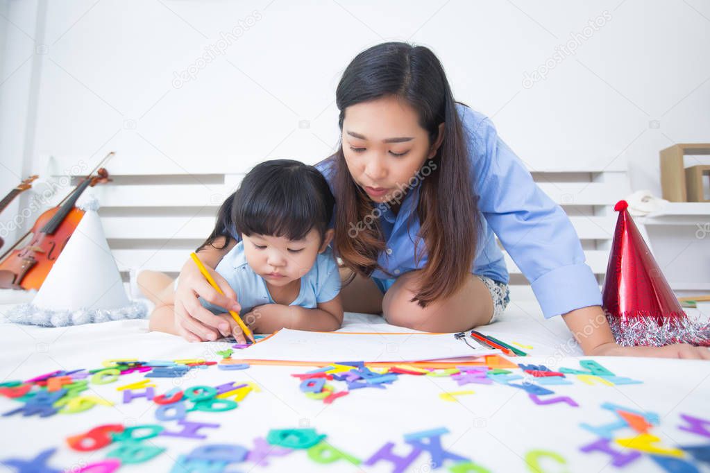 Mother and daughter studying the alphabet