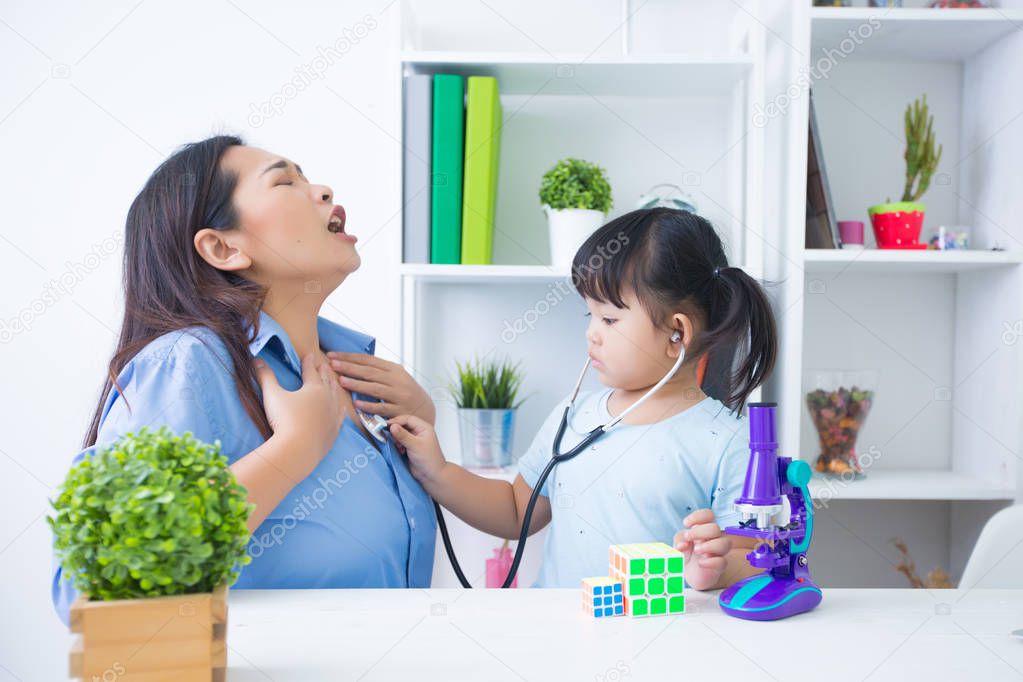 Mother and daughter playing doctor with stethoscope