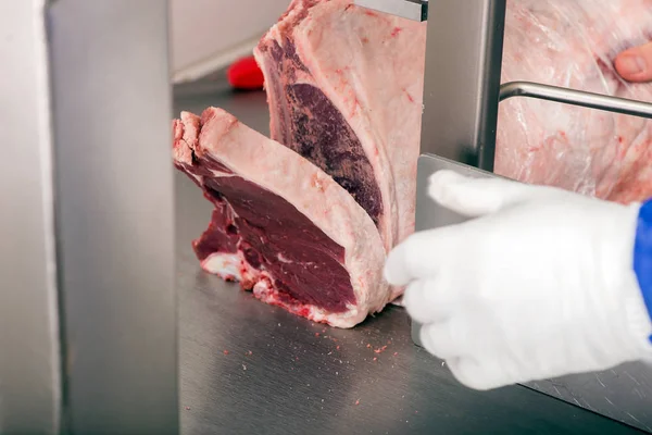 band saw cuts meat in a meat shop