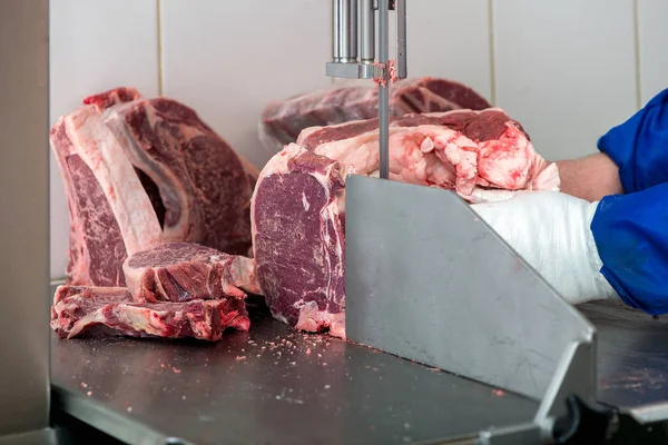 band saw cuts meat in a meat shop