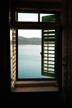 Deniz manzaralı Panjur günbatımı zaman ile eski penceresinden