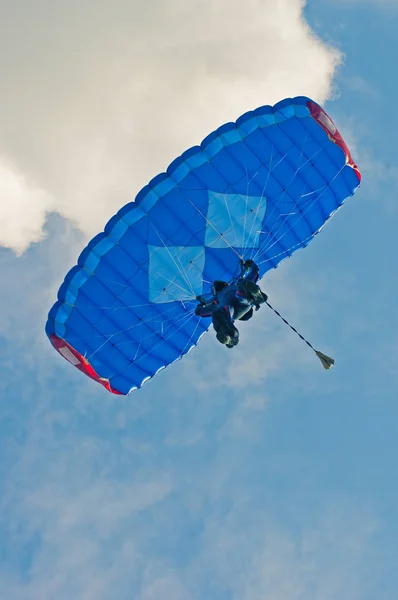 Mavi bir gökyüzü üzerinde para-planör mavi paraşüt ile düşük açılı görünüş — Stok fotoğraf