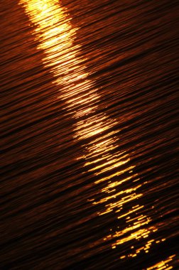 Batan güneşin ışığını yansıtan su yüzeyi