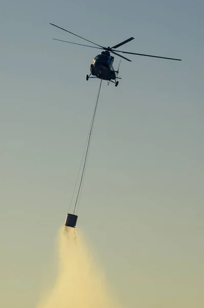 Военный вертолет тушит лесной пожар на Истрии Хорватия на закате — стоковое фото