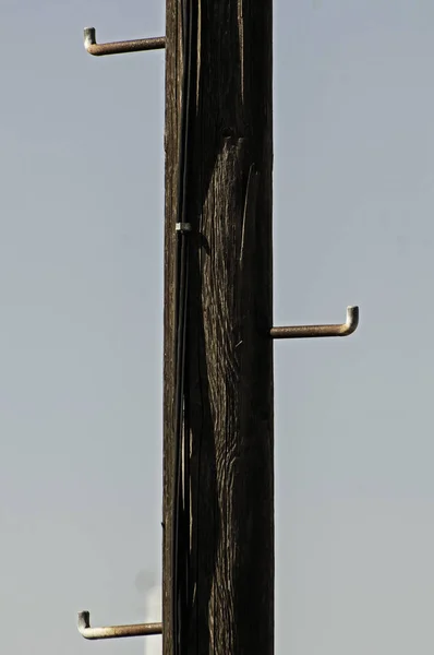Ancien pilier de ligne électrique en bois avec pieds en acier — Photo