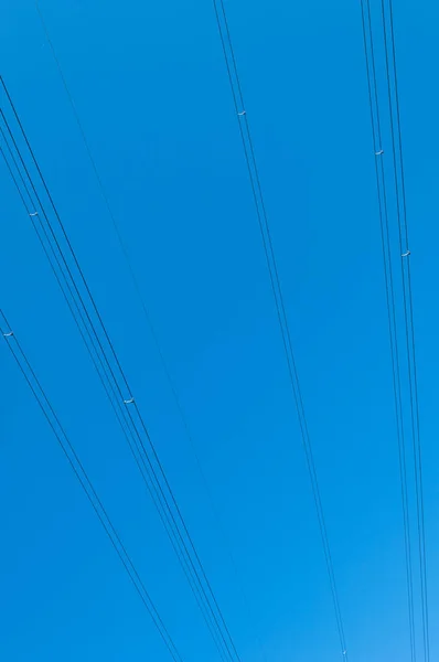 Кабели высоковольтных линий электропередач на голубом небе — стоковое фото