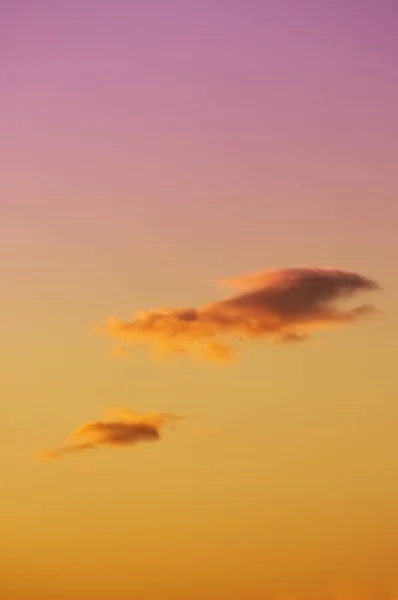 Nuvens solitárias no majestoso céu colorido laranja a roxo — Fotografia de Stock