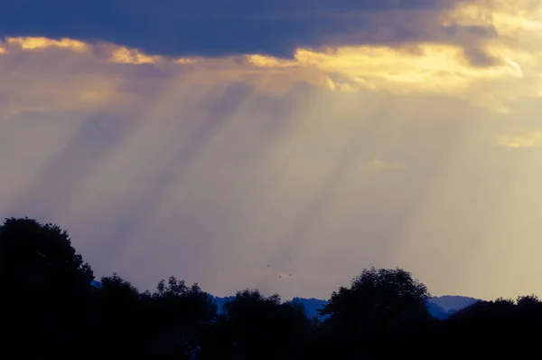 Sun rays breaking through the clouds of the evening sky