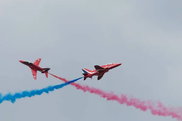 İki kırmızı Raf Hawks dar birbirlerinin uçuş yolu geçiş airshow üzerinde — Stok fotoğraf