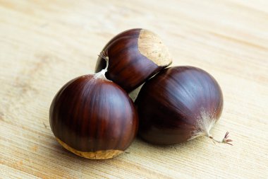 Bambu kesme tahtası üzerinde üç kestane closeup ağaçtan