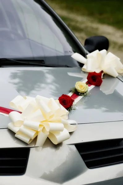 Closeup of wedding car decorated with rose flowers and ribbons