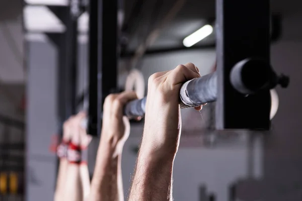 Erkek el bir spor salonunda bir Pull-up bar holding detay