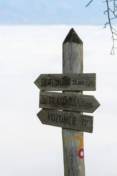 老风化木标志岗位与小道标记指向不同的地点在雾蒙蒙的背景 — 图库照片