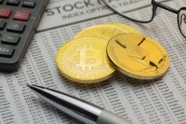 Closeup mockup gazetesi finansal sayfa hisse senedi seçenekleri, görünür gözlük, hesap makinesi ve tükenmez kalem ile altın Bitcoin ve Ethereum demir
