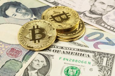 Dört Bitcoin cryptocurrency para closeup bize doları, Japon yeni ve Euro banknot üstüne koydu