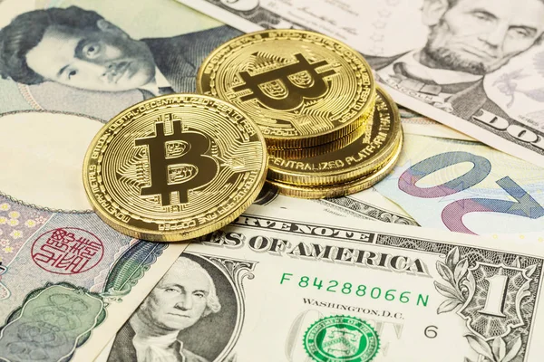 Dört Bitcoin cryptocurrency para closeup bize doları, Japon yeni ve Euro banknot üstüne koydu