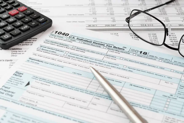 Kalem, hesap makinesi ve gözlük olan ABD bireysel gelir vergisi beyannamesi form 1040. Vergi, muhasebe, işletme, finans ve office kavramları.