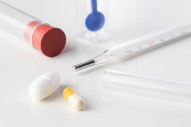 Merkür termometre, cam boru ve beyaz arka plan üzerinde izole dışkı testi örnekleyici haplarla. Laboratuvar, antibiyotikler, ilaç, eczane, cerrahi ve Pediatri kavramları.