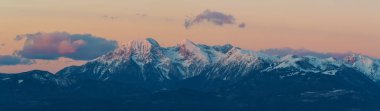 Majestic view of snowcapped alpine peaks of Karawanks and Krvavec ski resort slopes in Slovenia right before sunset. Alps, mountaineering, travel, skiing, winter sports and beautiful nature concepts. clipart