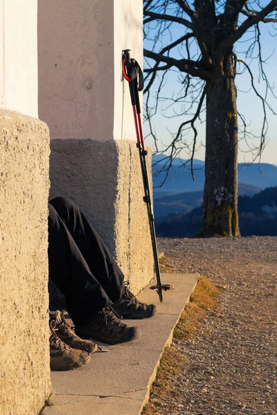 Két túrázók pihenő, látható csak a lábak és a gyalogos pólusok támaszkodott a falnak — Stock Fotó