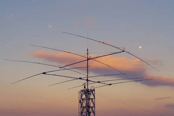 Telekomunikační anténa na ocelové věži a v šeru na pozadí — Stock fotografie