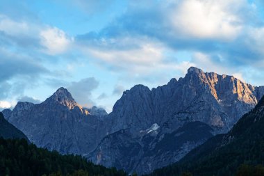 Gün batımında Slovenya'da Julian Alpleri'nin yüksek zirvelerinin görkemli manzarası