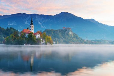 Sabah göl kanadı. Adadaki kilise, arka plandaki şato ve dağlar
