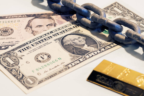 Один и пять долларов купюры, слитки золотой и стальной цепи. Деньги, финансы, долг, золотой стандарт и амортизационные концепции