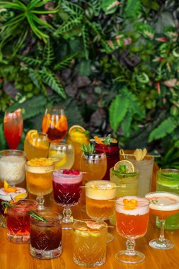 Ahşap masada meyveli alkollü çok renkli kokteyller..