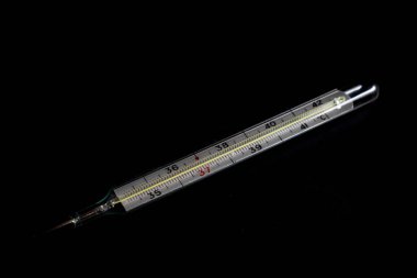 Siyah bir arka plan üzerinde vücut sıcaklığı ölçme termometresi
